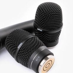 Two professional handheld microphones lying against each other on a white background, with a focus on the quality construction and design details.
