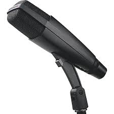 A close-up of a black handheld microphone with its stand.