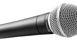 A close-up image of a shure brand handheld microphone against a white background.