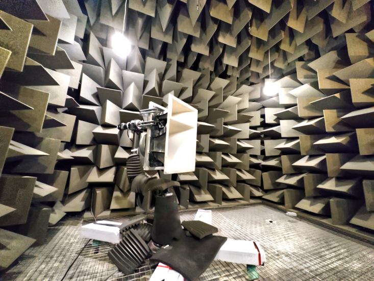 Loudspeaker mounted on robot arm in anechoic chamber at University of Salford